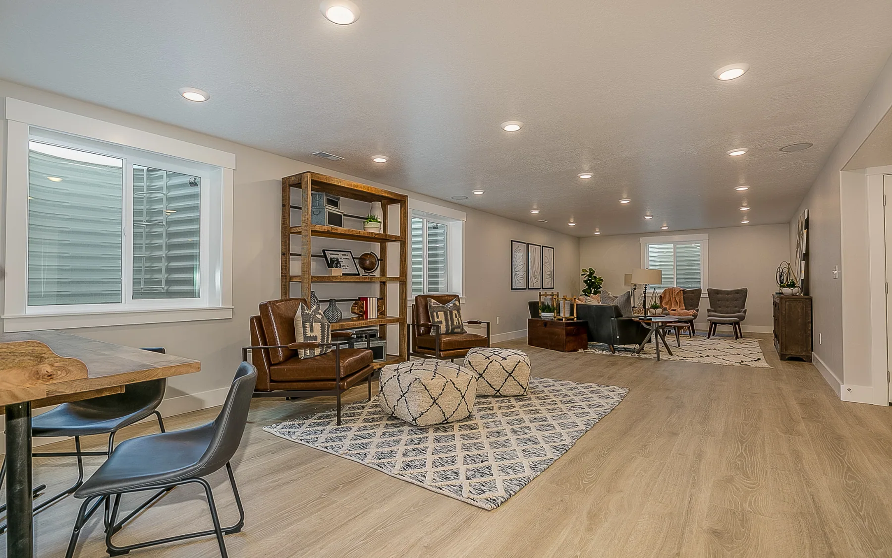 Finished basement living and dining space with plank flooring and daylight windows in Dacula, GA