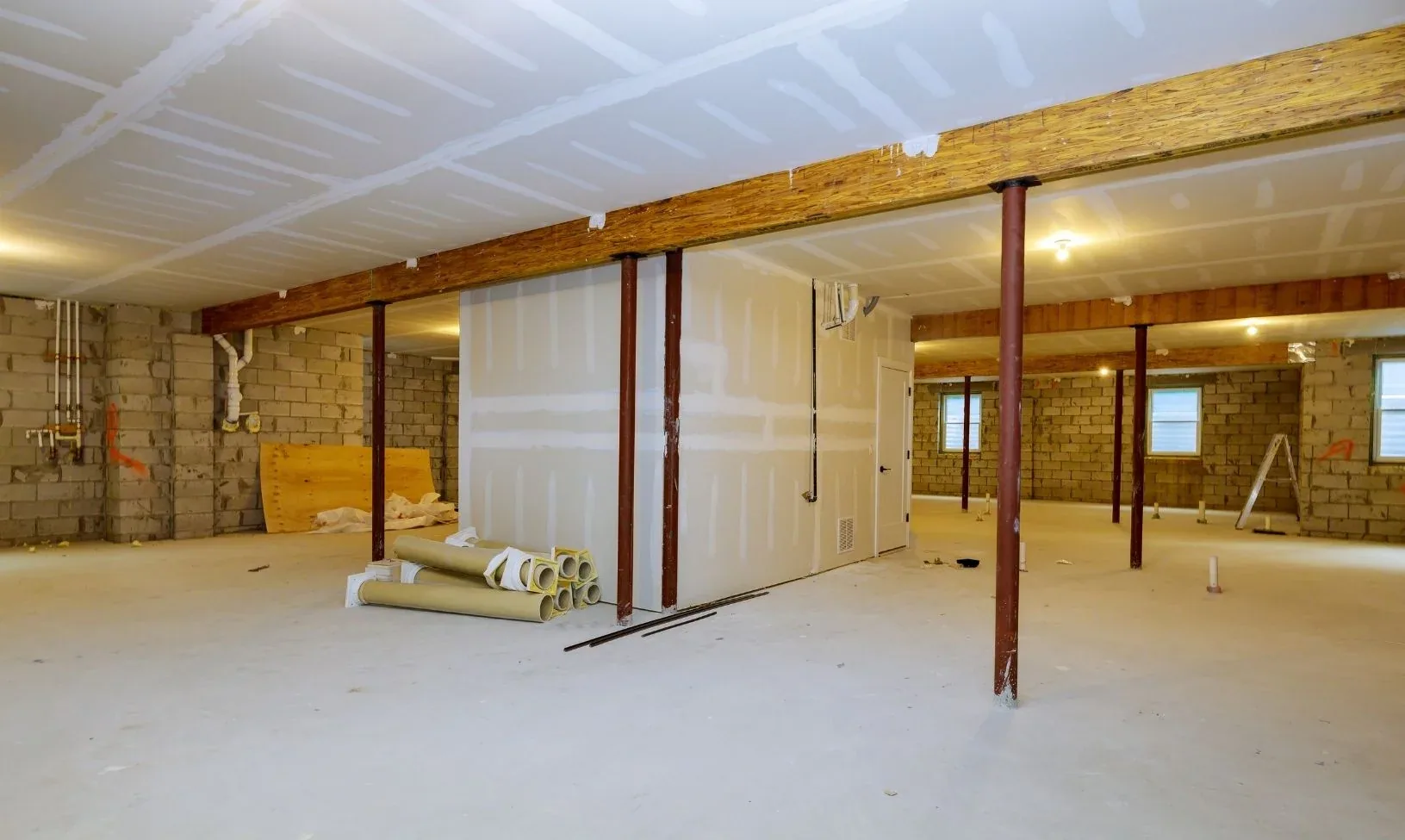 Unfinished basement with bare block walls and steel columns before finishing work in Buford, GA