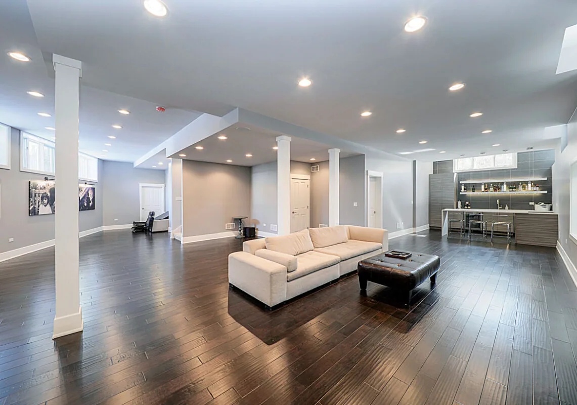 Finished basement with dark hardwood flooring, a seating area and kitchenette in Snellville, GA