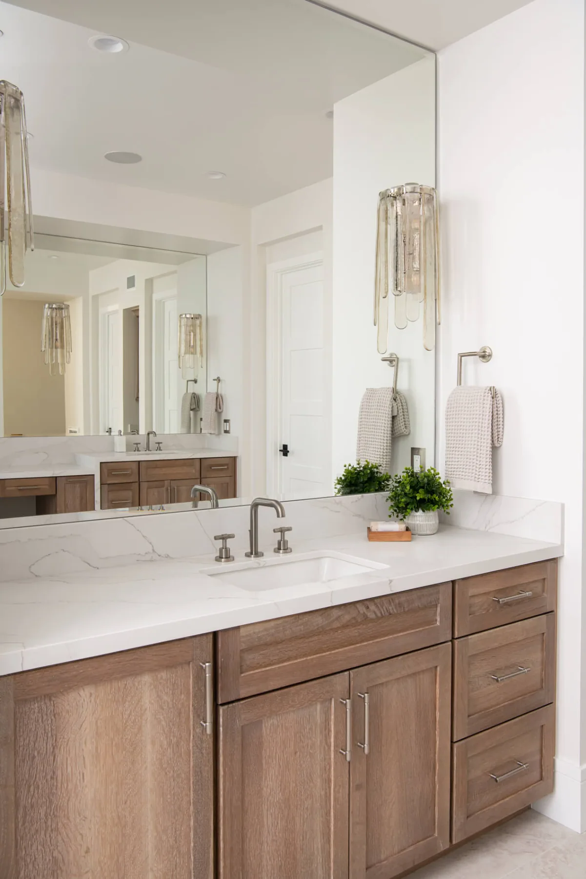 Wood vanity with a quartz top and full-height mirror in a finished Duluth, GA bathroom remodel