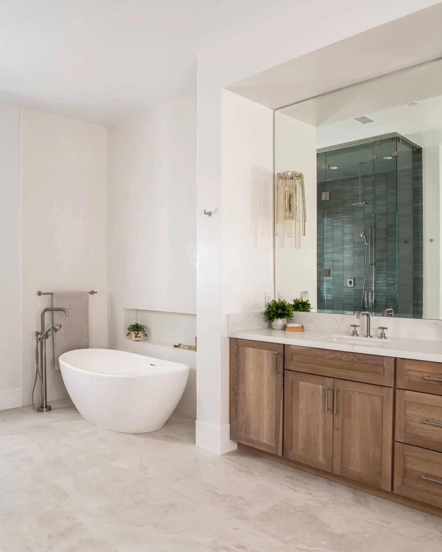 Freestanding soaking tub beside a wood vanity and glass shower in a Loganville, GA bathroom