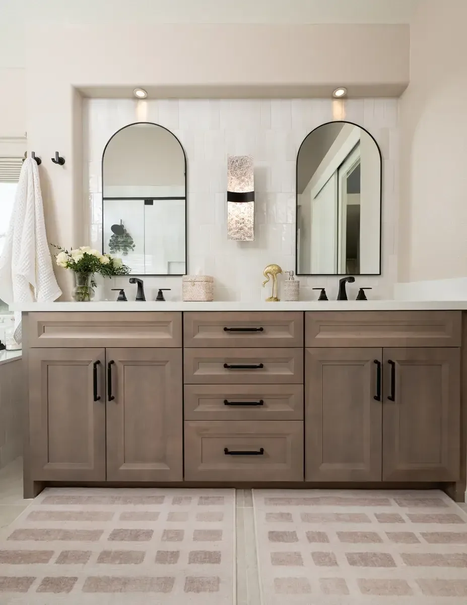 Arched mirrors and brushed hardware over a double vanity in a Snellville, GA bathroom remodel