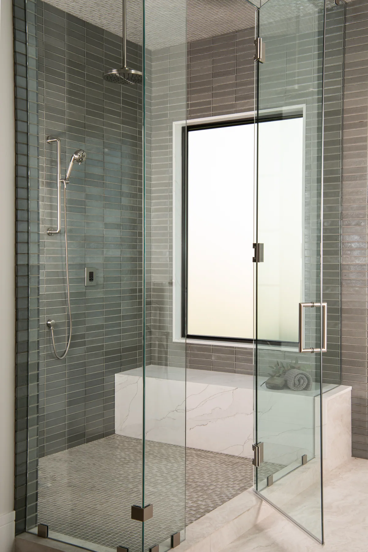 Frameless glass walk-in shower with green stacked tile and a built-in bench near Lilburn, GA