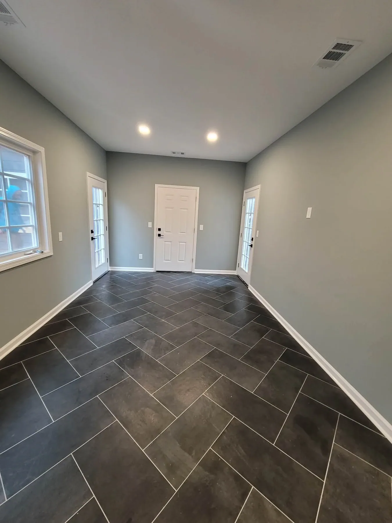 Dark herringbone tile flooring installed across an entry and hallway in Duluth, GA