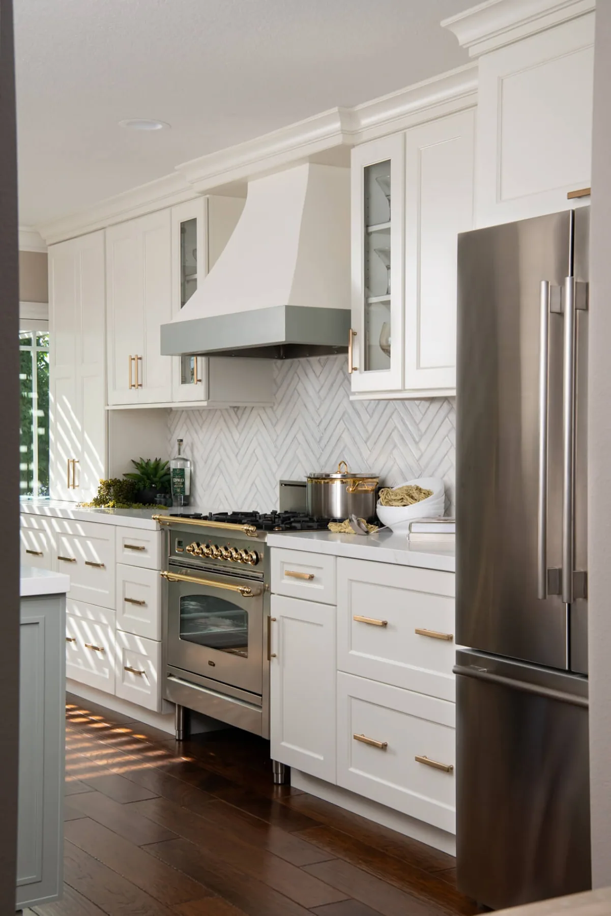 Galley view of a white kitchen remodel with hardwood flooring and a pro range near Lilburn, GA