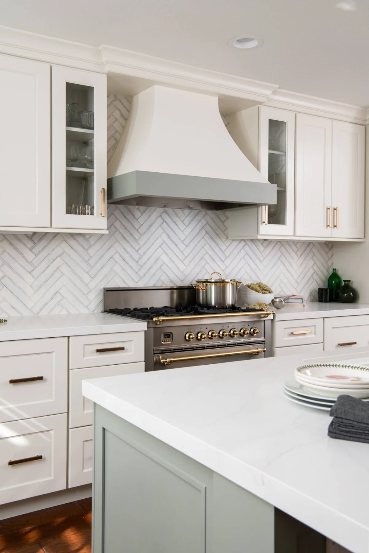 Plaster range hood and quartz island detail in a completed Snellville, GA kitchen remodel