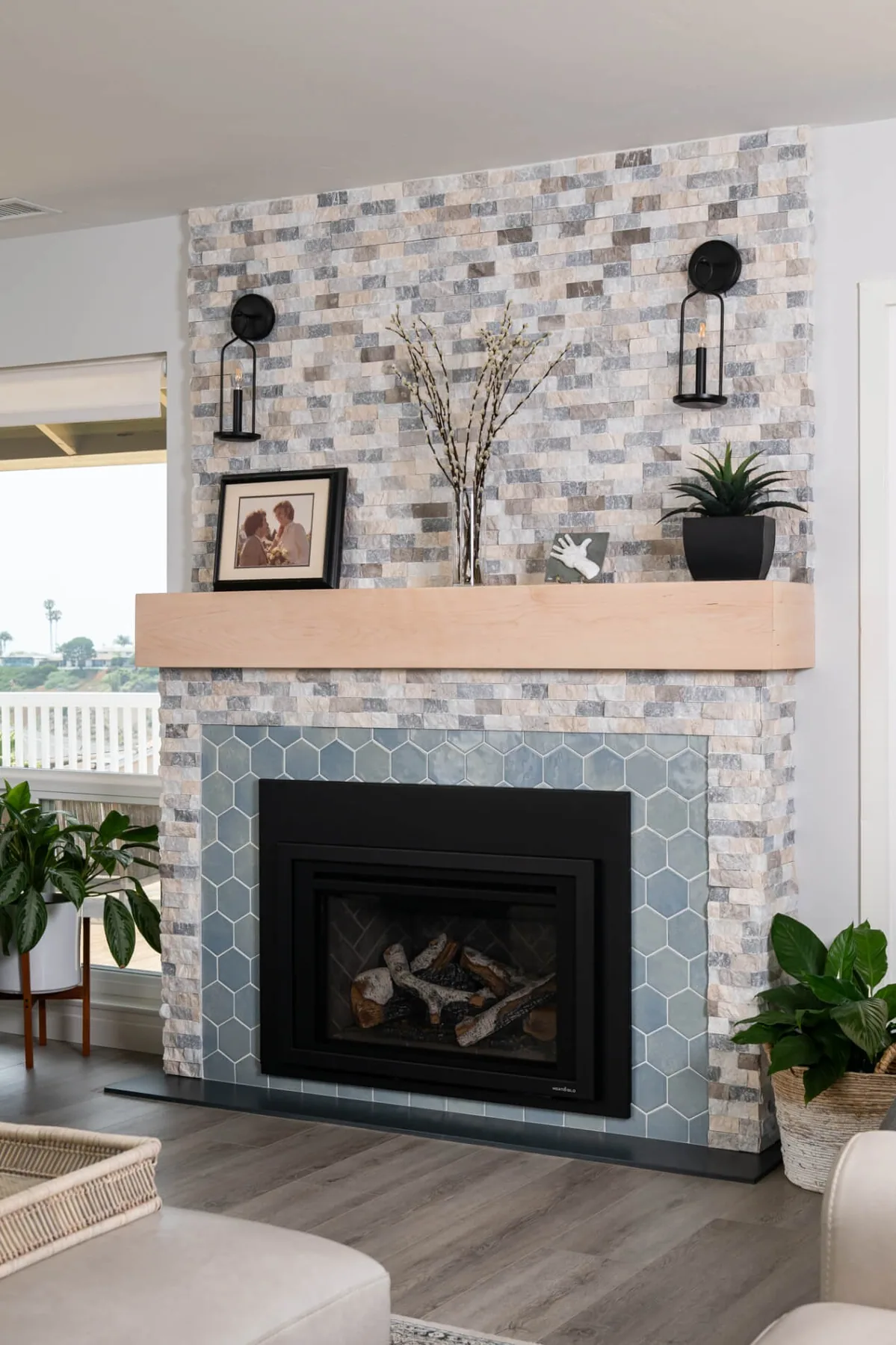 Stacked tile fireplace with a wood mantel and plank flooring in a Gwinnett County living room