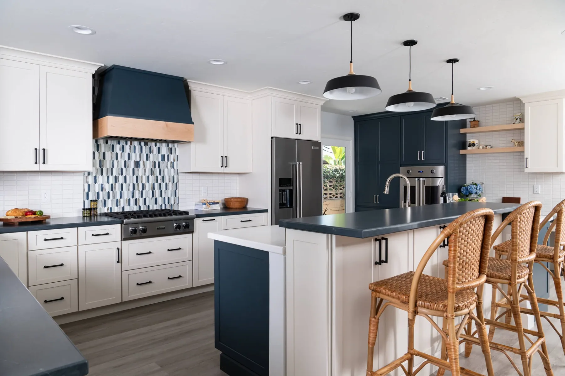 Navy range hood and island with black pendants in a completed Lawrenceville, GA kitchen