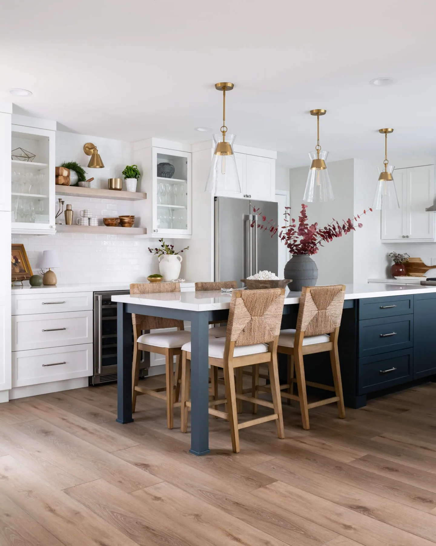 Light wide-plank flooring running under a kitchen island and dining table in Dacula, GA