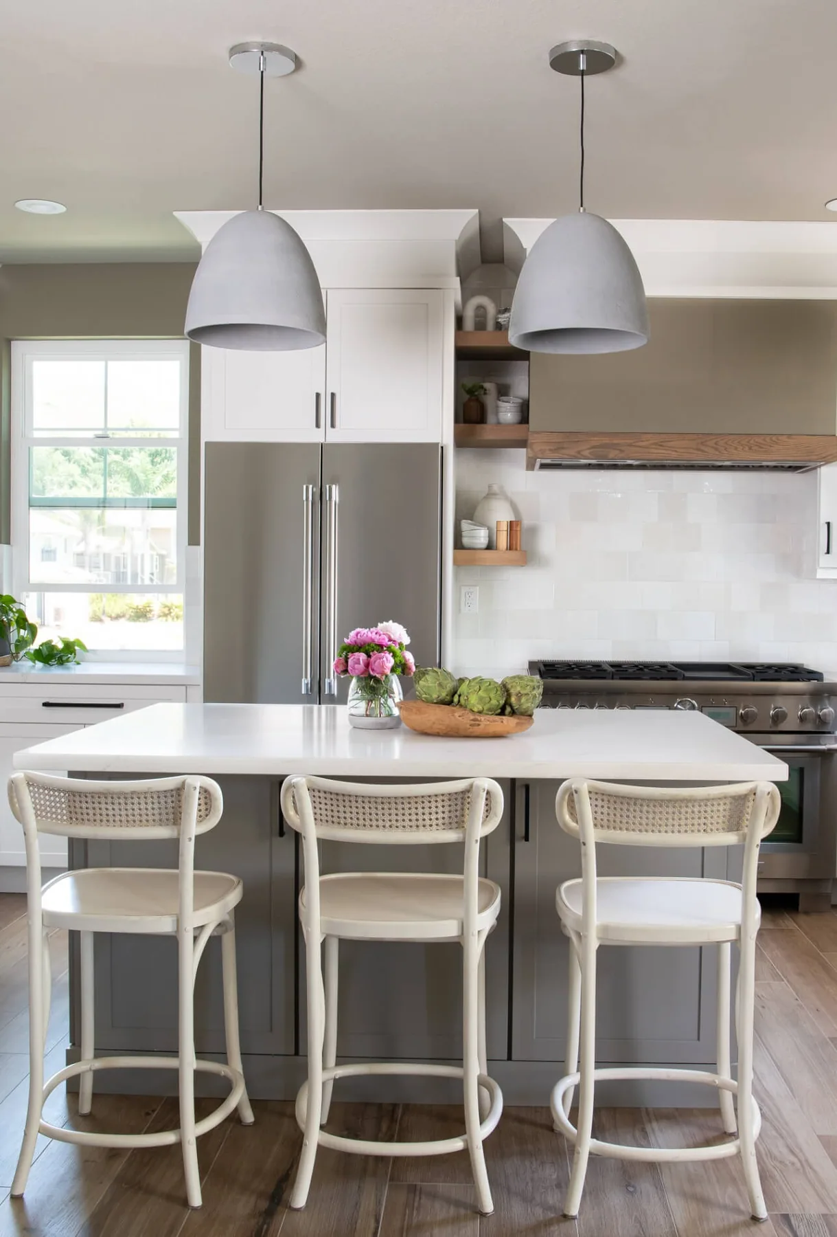 Quartz island with cane bar stools in a bright white kitchen remodel near Snellville, GA